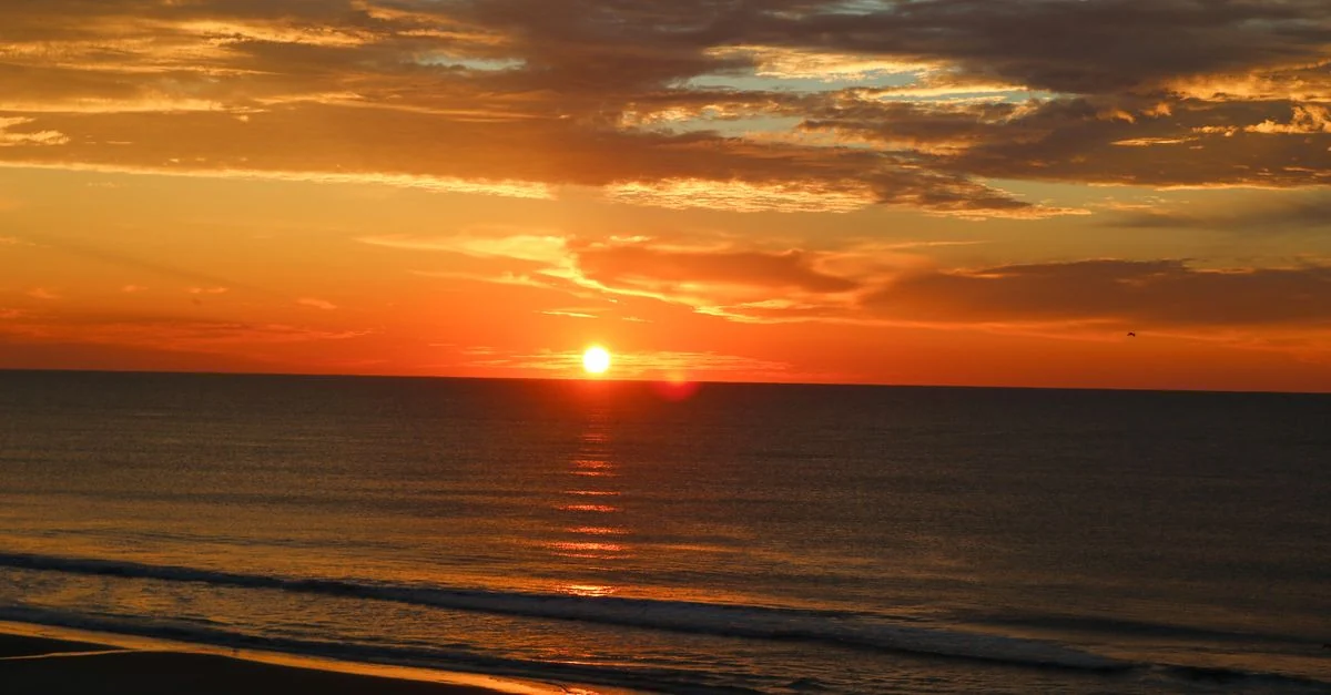 Beautiful sunset view with vivid colors over a calm ocean shore.