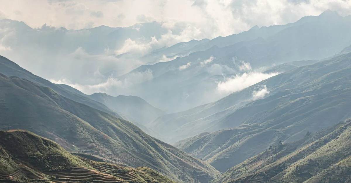 Scenic mountain landscape with terraces under cloudy sky with valleys and peaks.