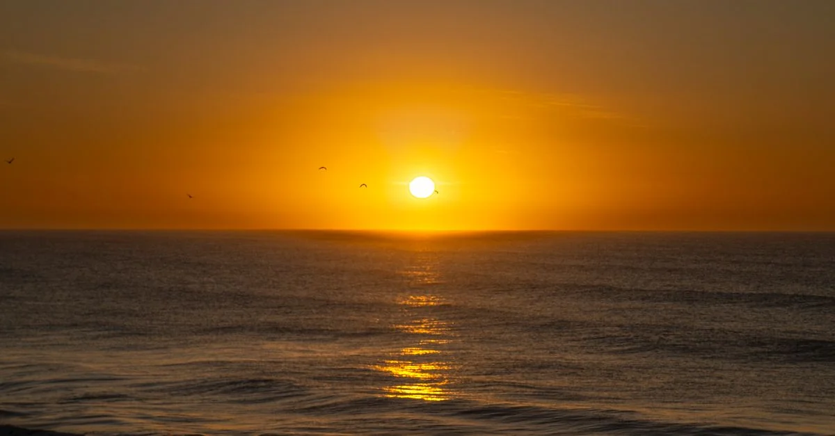 Breathtaking sunrise over the Atlantic Ocean at Mar del Plata, Argentina. Calm waves and vibrant colors.