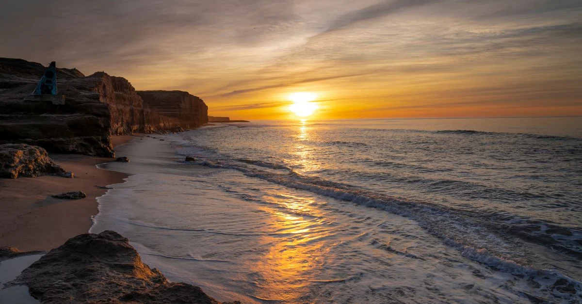 Capture the serene beauty of a golden sunrise over Mar del Plata beach in Argentina.