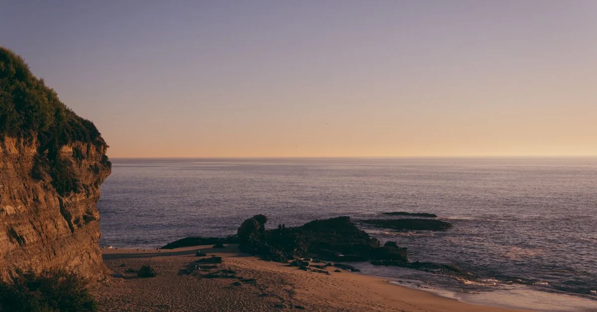 Captivating sunset view of a serene beach with cliffs in San Diego, California.