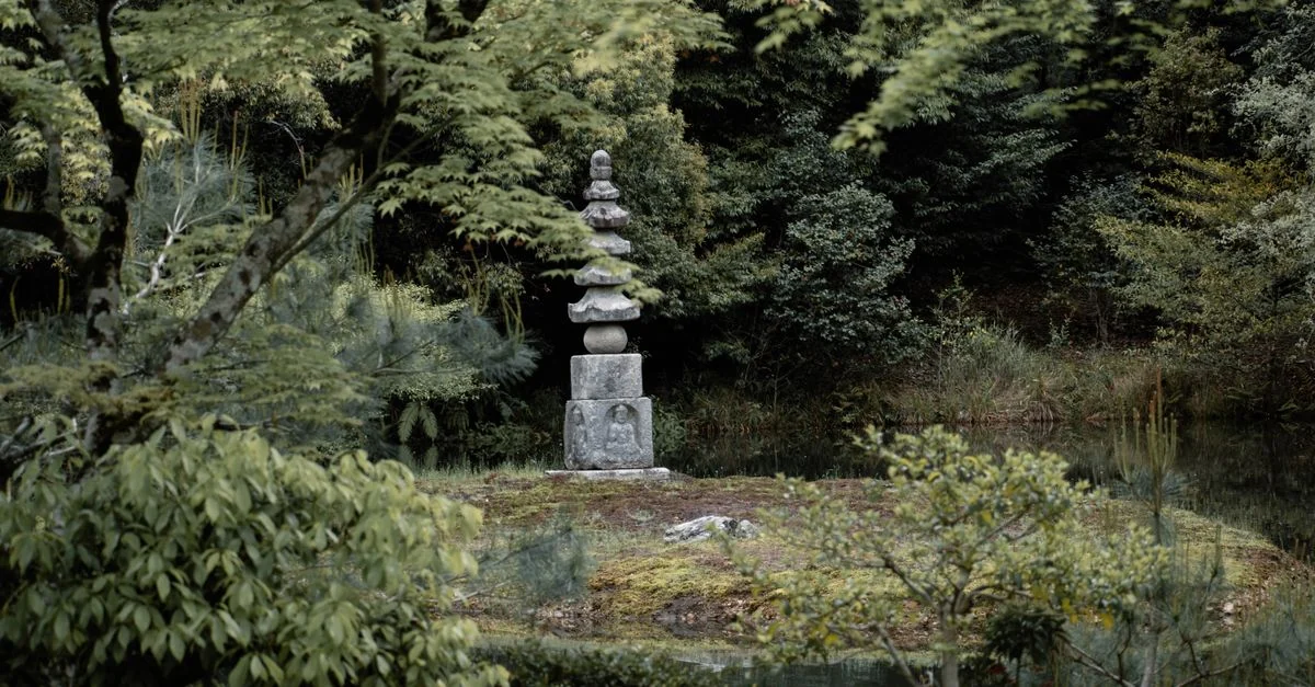 Tranquil Japanese garden scene featuring ancient pagoda surrounded by lush greenery in Kyoto, Japan.
